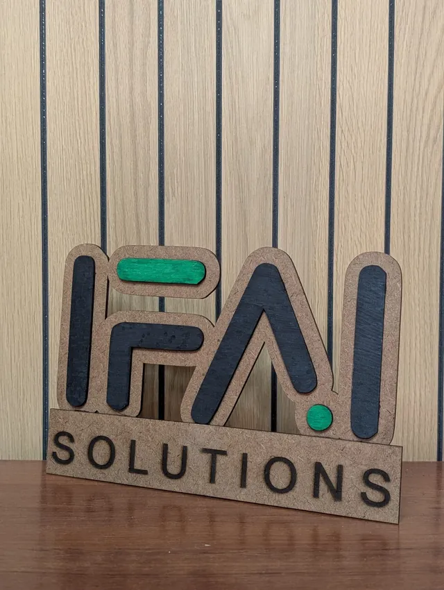 Cartel de madera en capas con el logotipo de IFAI Solutions, letras en negro y detalles en verde