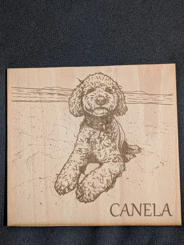 Retrato de un perro grabado sobre madera con el nombre Canela