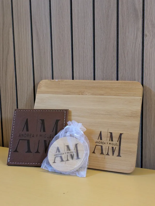 Conjunto de posavasos, colgante y tabla con el monograma A M